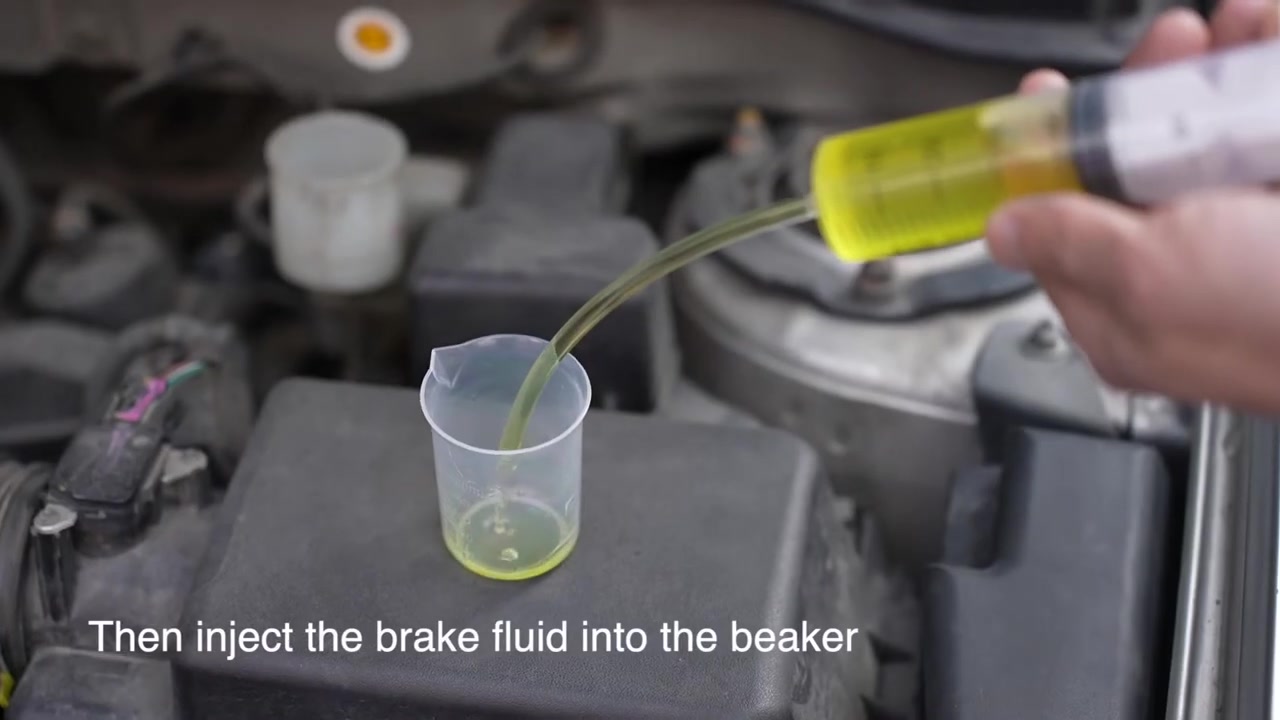 Brake fluid being transferred from a dedicated syringe into the AUTOOL AS506 beaker