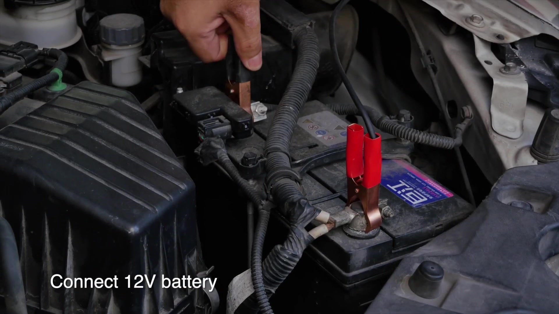 AUTOOL ATF702 red and black clamps connected to a vehicle 12 V battery