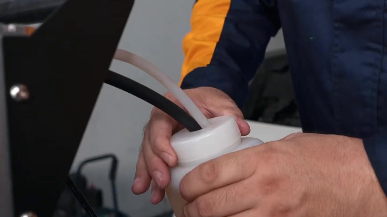 Two AUTOOL AST609 bottle-side hoses positioned through the cap of the external new-fluid bottle.