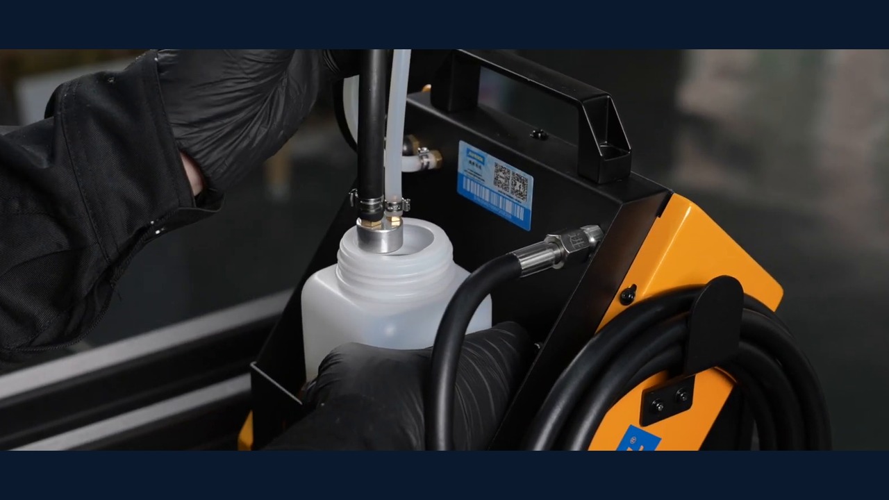 Two AUTOOL AST612 bottle-side hoses positioned through the cap of the external new-fluid bottle.