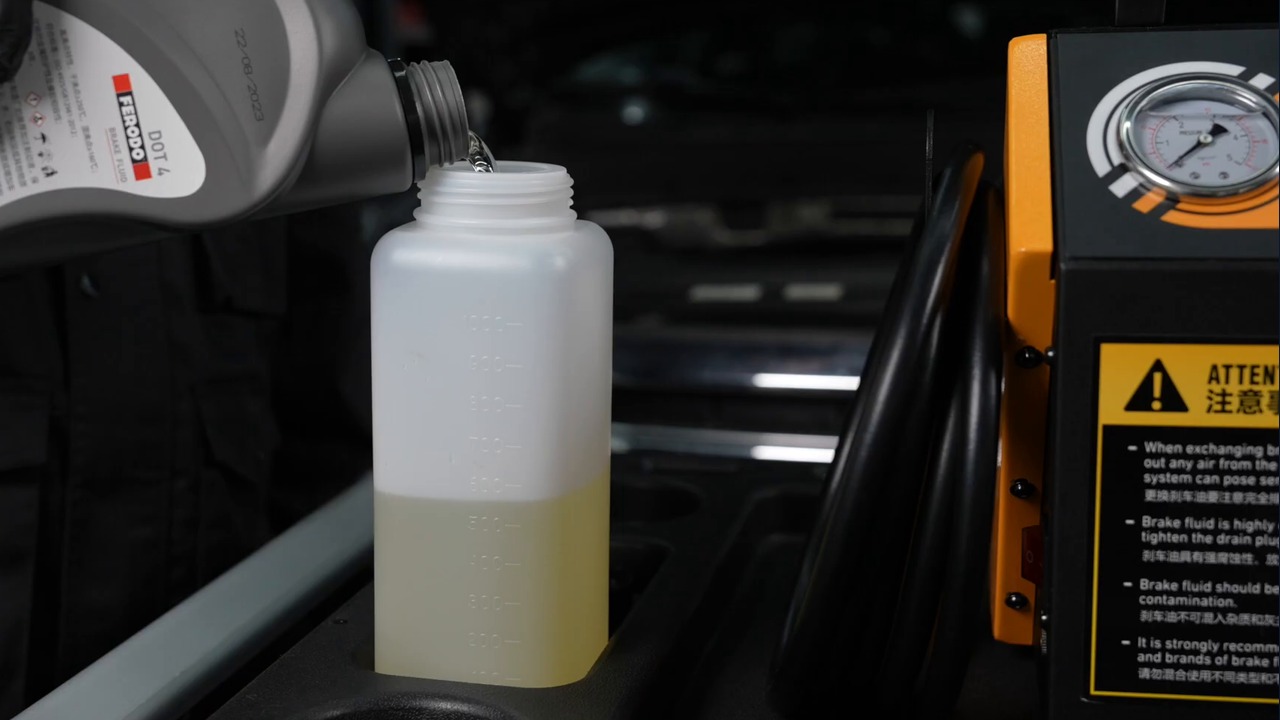 Operator pours labelled new brake fluid into the AUTOOL AST612 rear supply bottle.