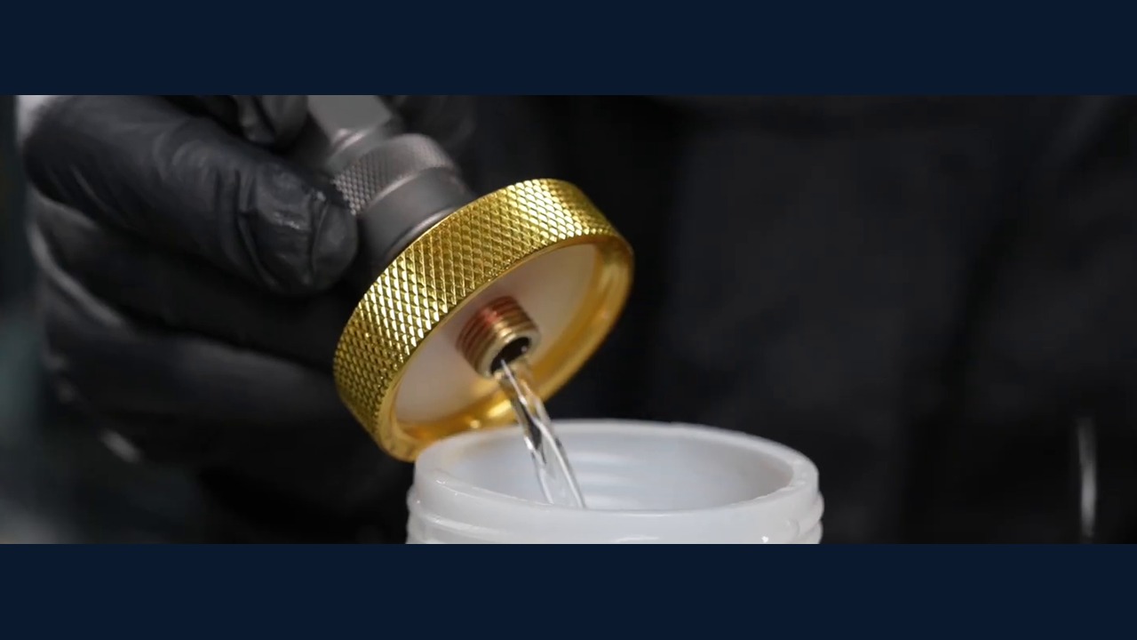 AUTOOL AST612 adapter outlet discharging fluid into a bottle during off-vehicle priming.