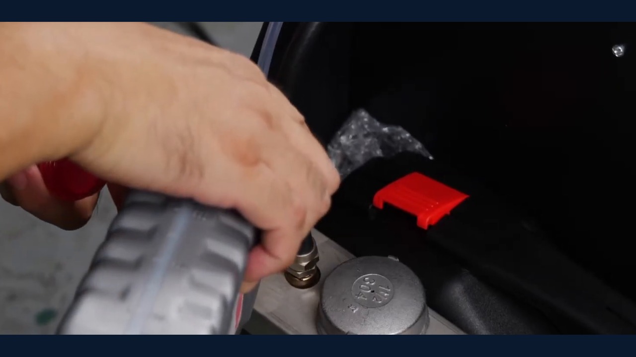 Operator pours brake fluid through the AUTOOL AST618 new-fluid tank filling port.
