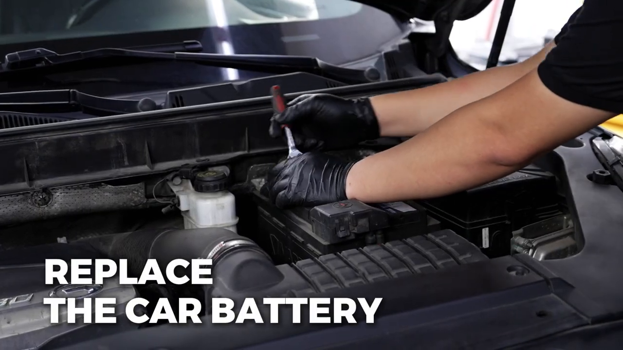Technician removing a vehicle battery connection while the AUTOOL BT30 backup path remains connected.