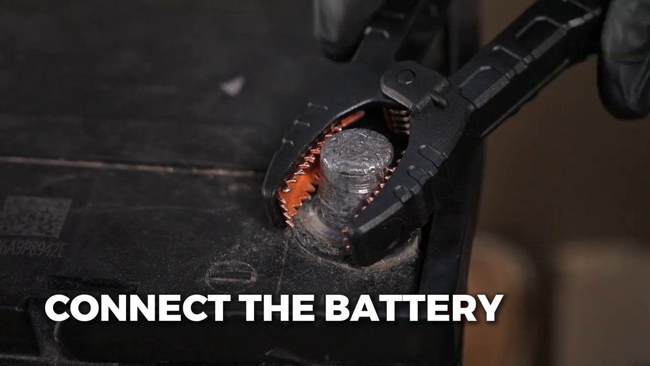 Insulated BT30 clamp attached to a clean terminal on a spare 12 volt vehicle battery.