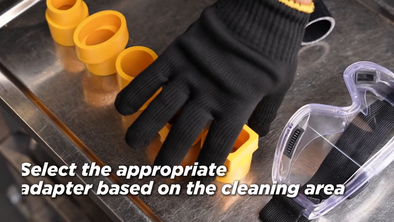 Gloved technician comparing yellow intake-port adapter shapes beside a clear protective visor.