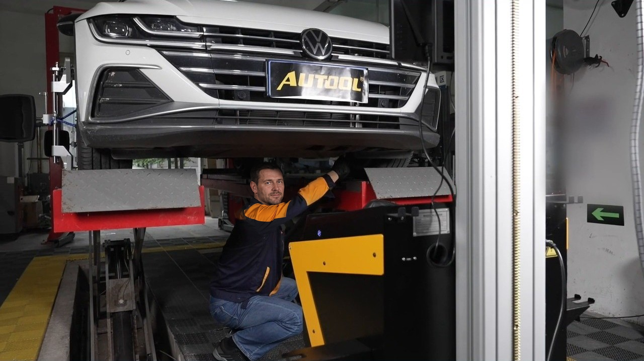 Technician adjusting vehicle suspension on the XC508 alignment rack