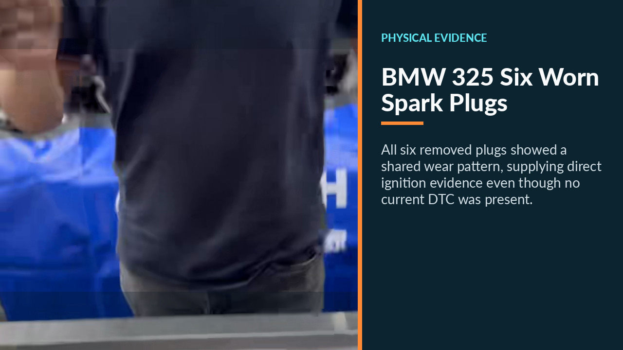 Six worn spark plugs removed from the BMW 325 and arranged for inspection.
