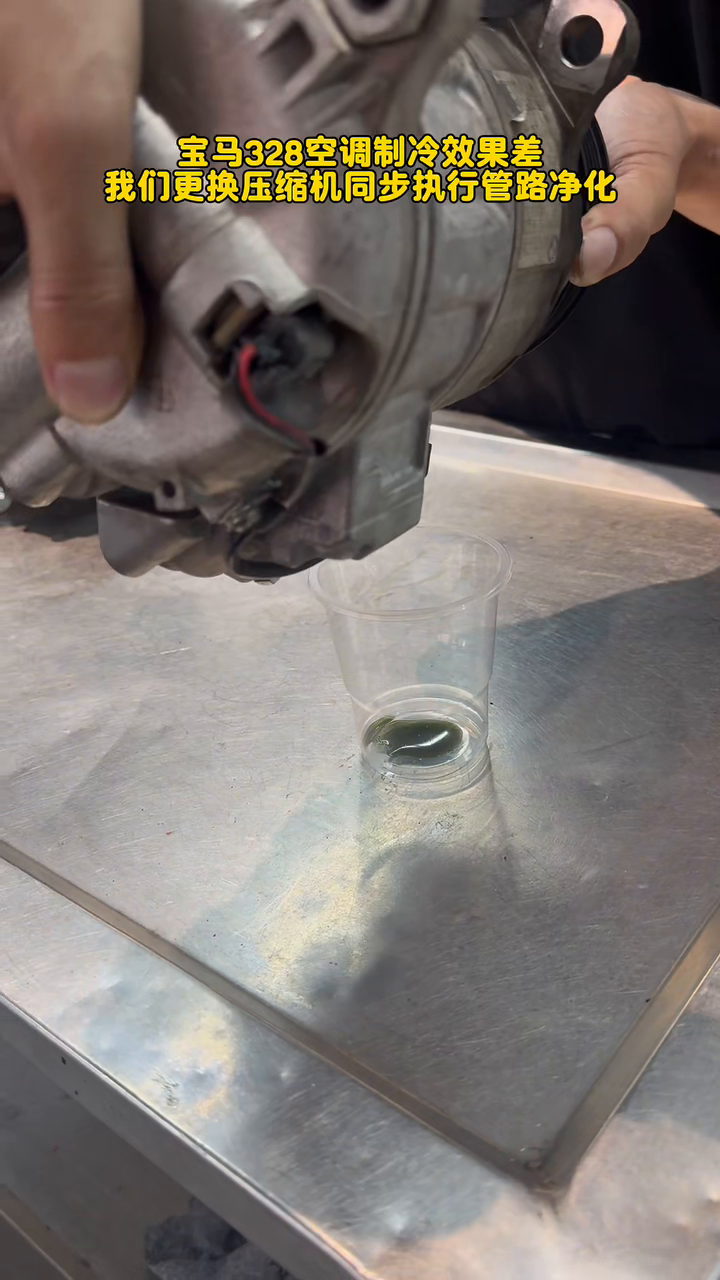 Dark compressor oil draining into the collection cup