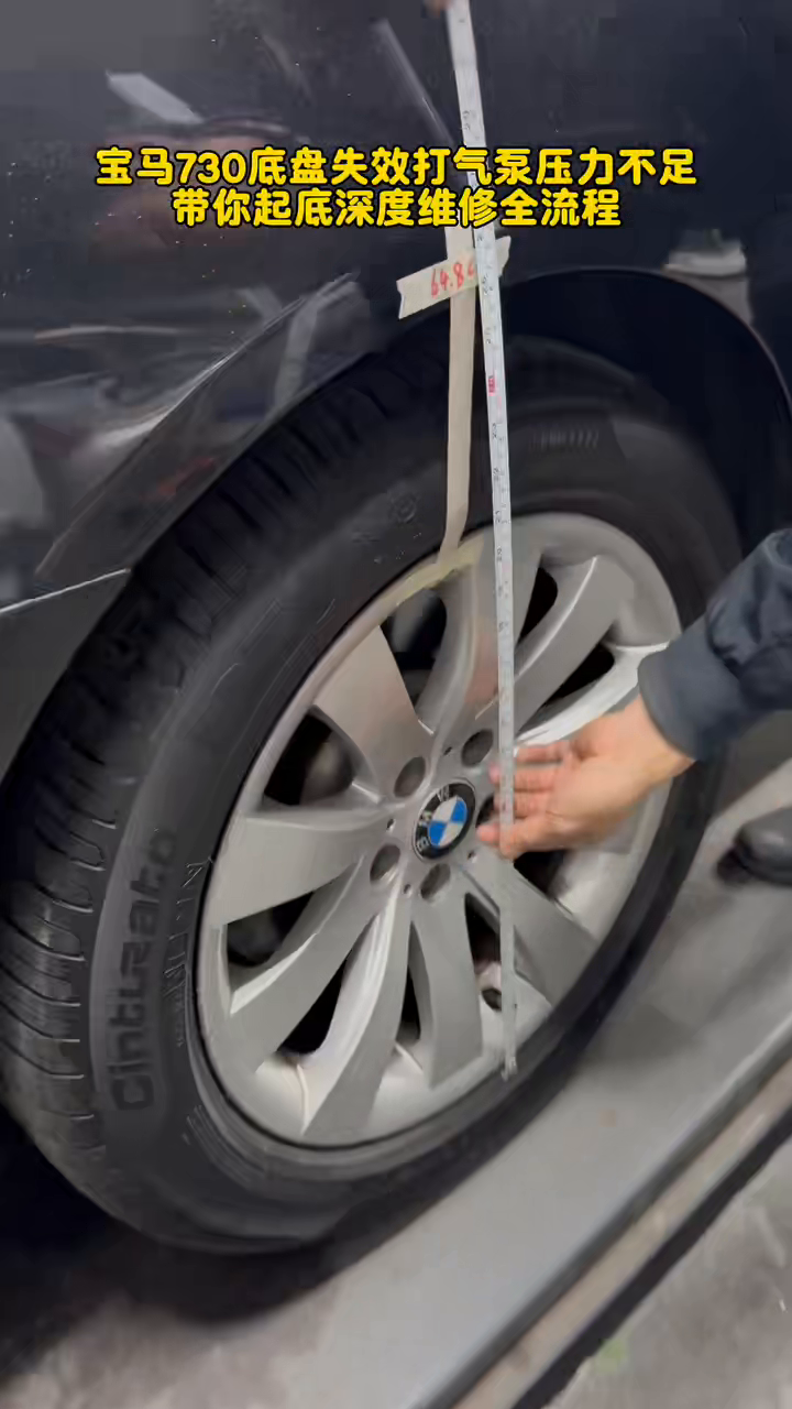 Ruler aligned at the BMW 730 rear wheel to record the restored suspension height.