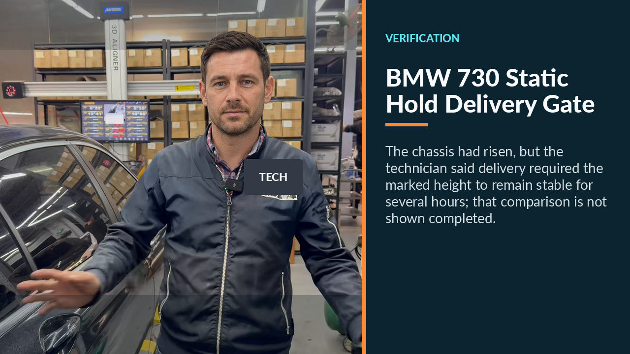 Technician beside the raised BMW 730 explaining that delivery depends on no further height drop.