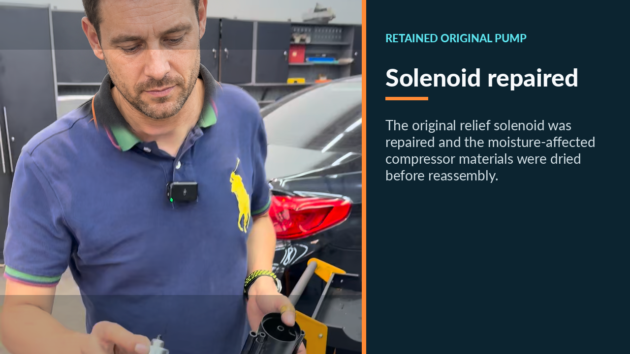 Technician holding the repaired relief solenoid and original compressor housing
