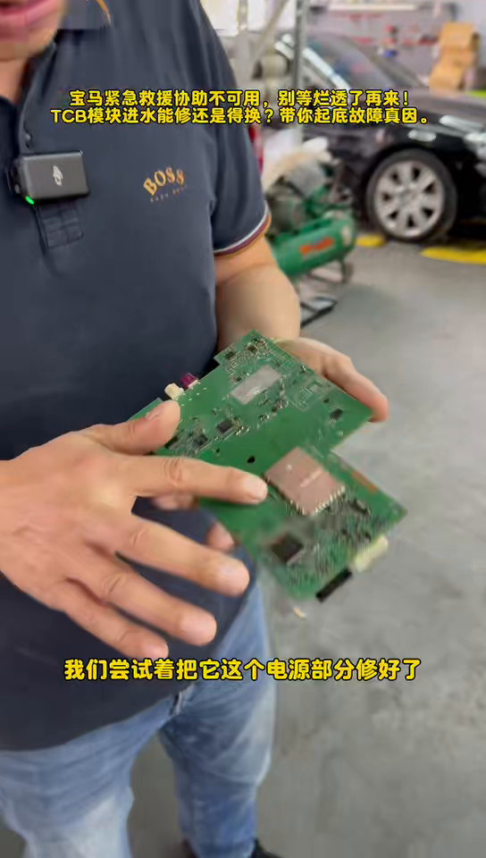 Technician holding the opened BMW TCB circuit board and pointing to the damaged area.