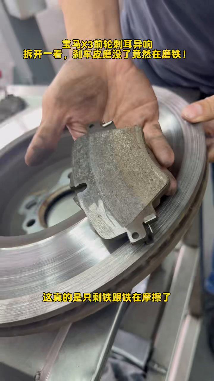 BMW X3 inner brake pad worn to its backing plate beside a scored disc