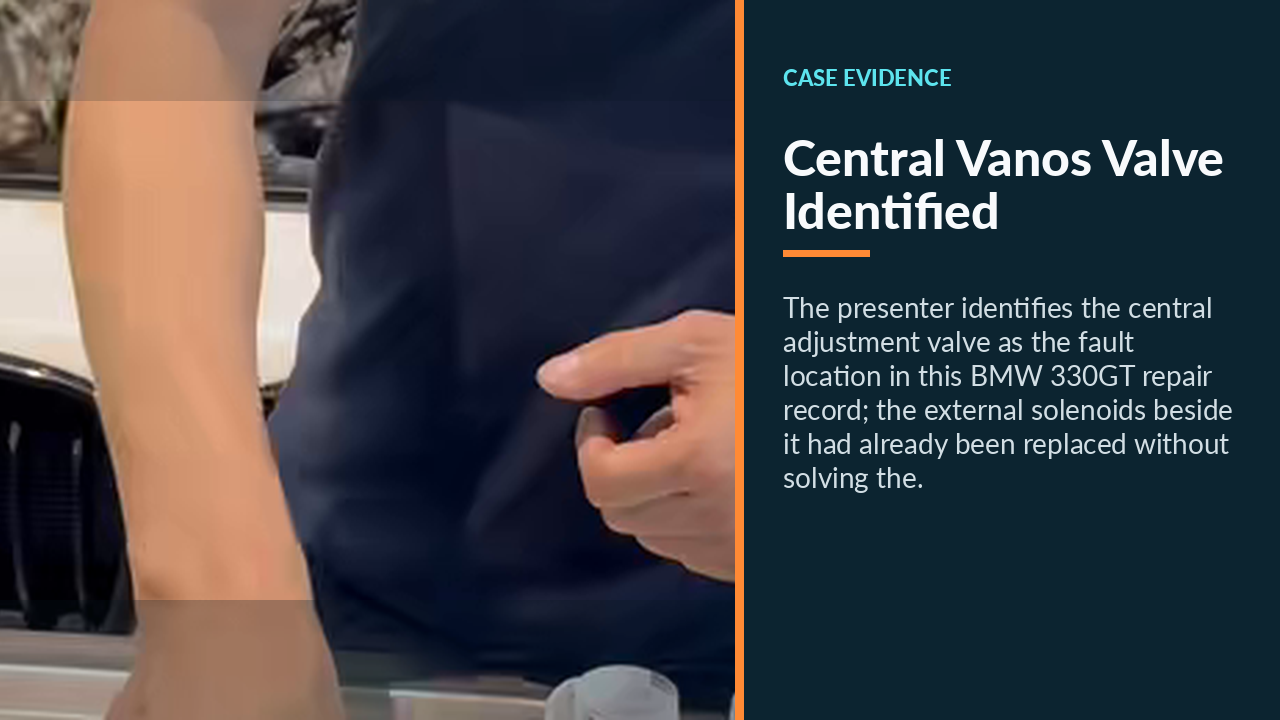 Presenter pointing to the BMW B48 central VANOS adjustment valve among the removed parts