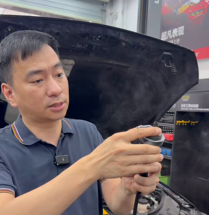 Technician holding the disconnected purge valve during the zero-voltage sealing test