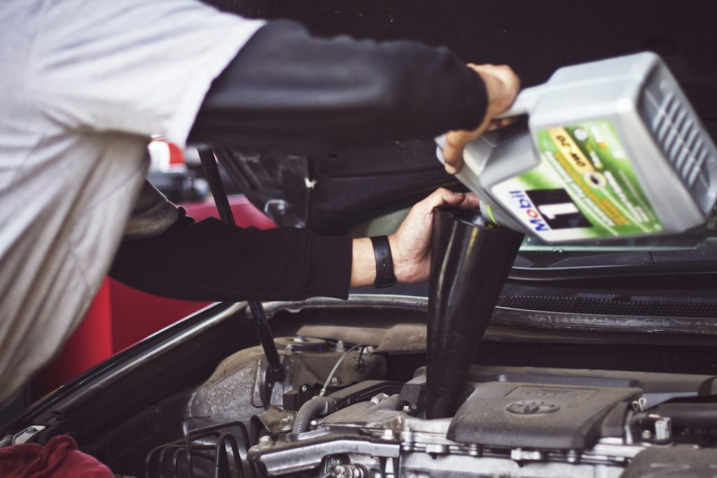 Technician inspecting a vehicle engine bay