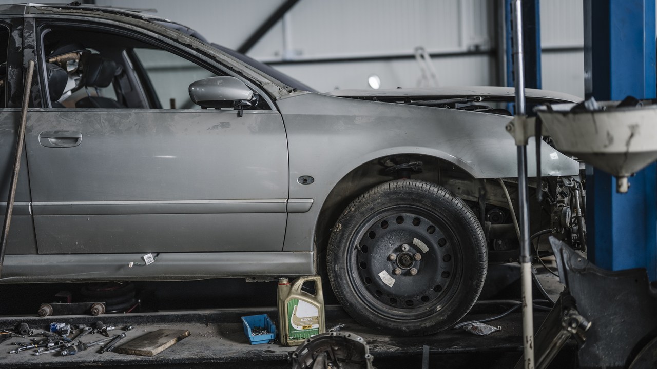 Partially disassembled car in a professional workshop with a lift
