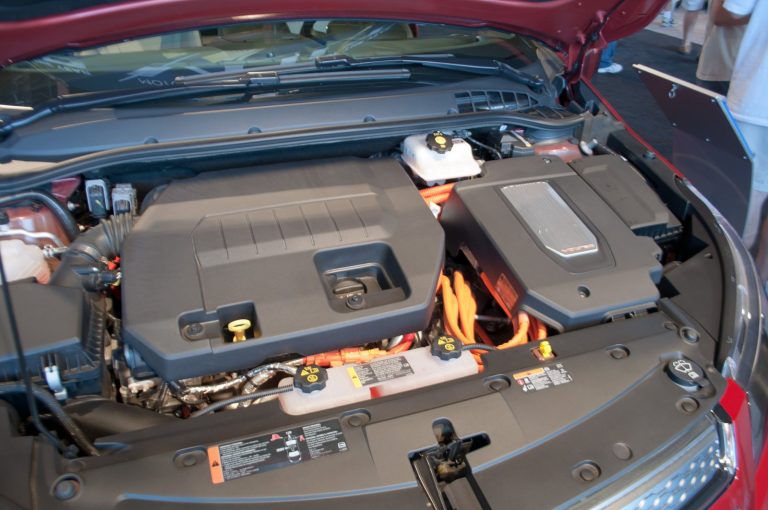 Open car hood showing the engine bay and battery components