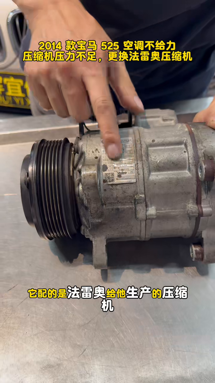 Close view of the A/C compressor removed from the BMW 525i.
