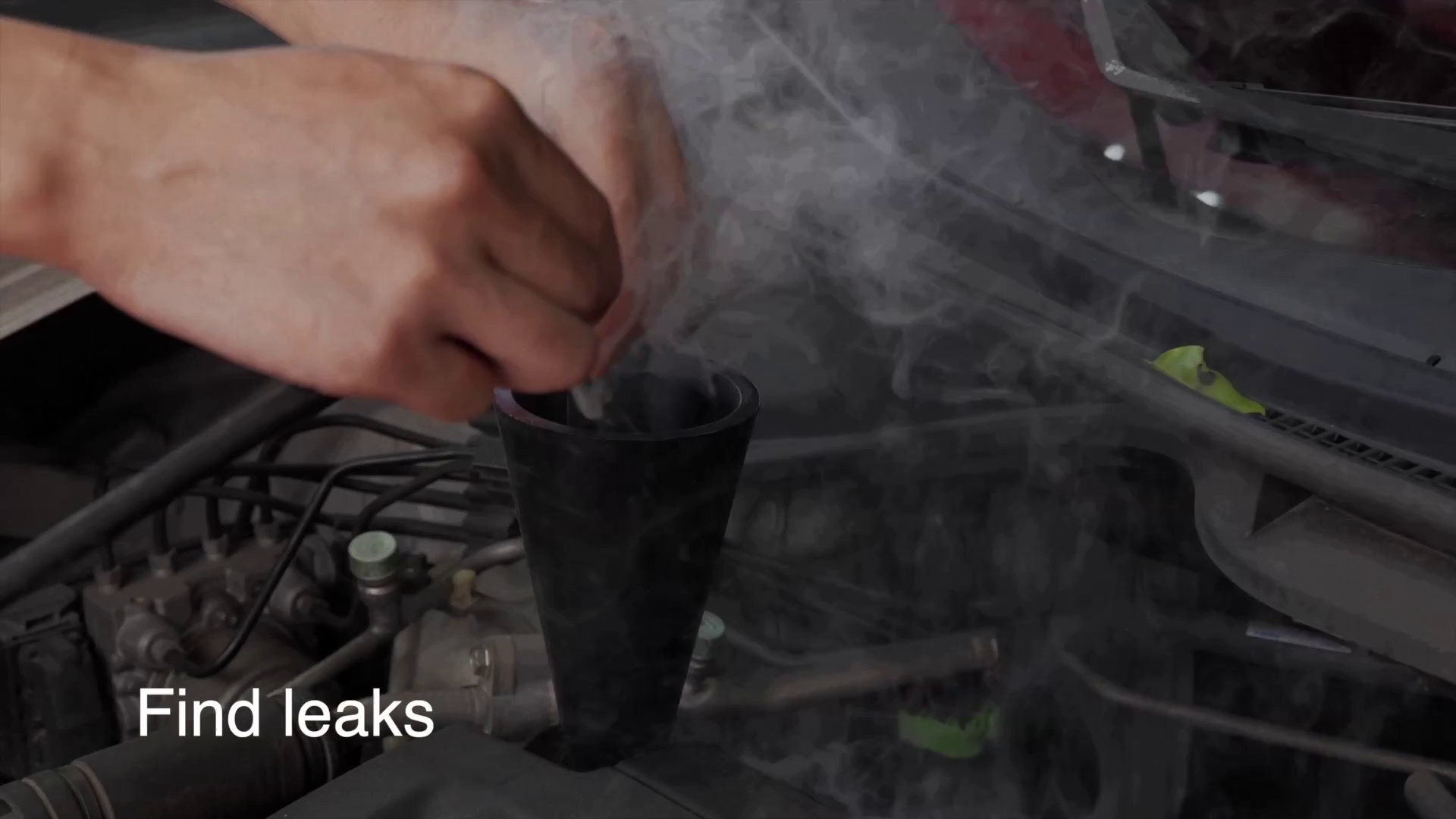 Visible smoke being inspected around an engine-bay test opening during an FXTUL F603 leak test