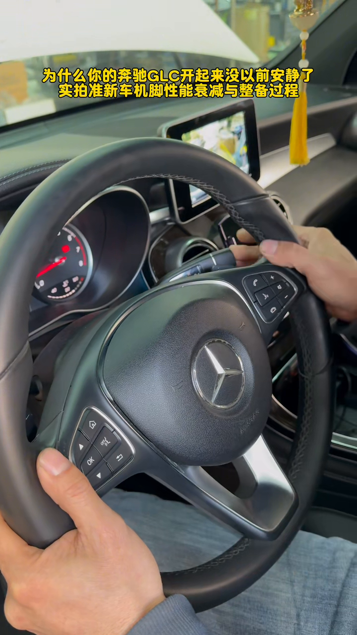 Hands on the GLC260 steering wheel during the post-repair idle vibration recheck