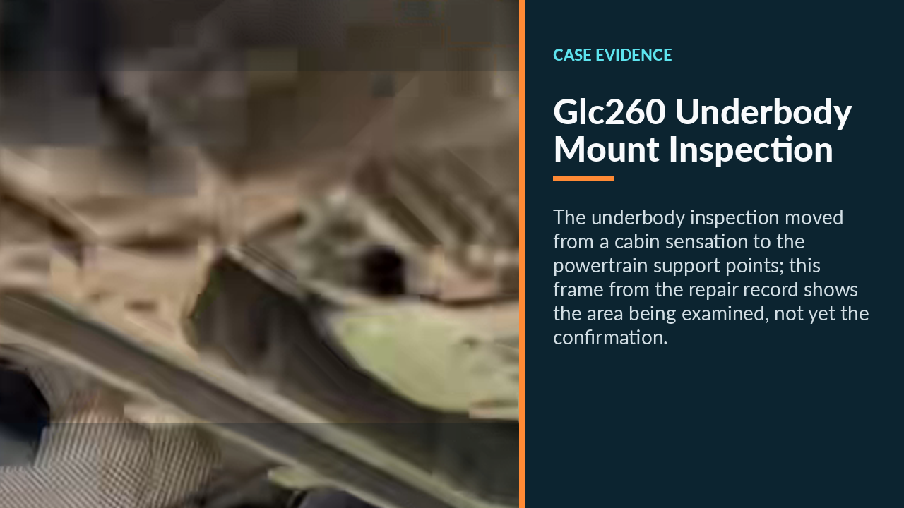Technician inspecting the GLC260 powertrain mount area from beneath the raised vehicle