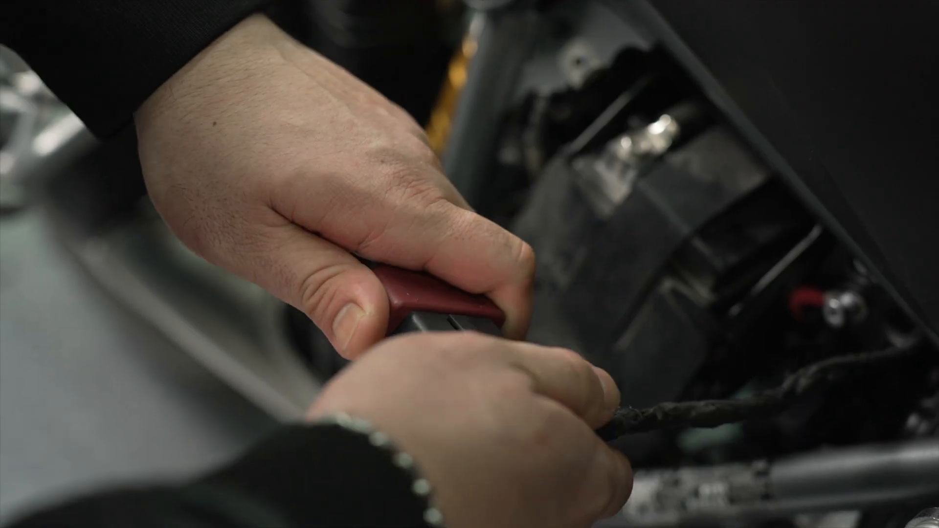 Technician connecting an FXTUL M3 adapter at a motorcycle diagnostic connector