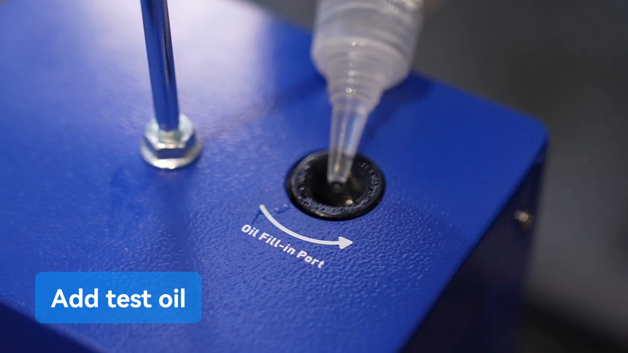 Approved smoke-test oil being measured into the MRCARTOOL T100 oil-fill port.