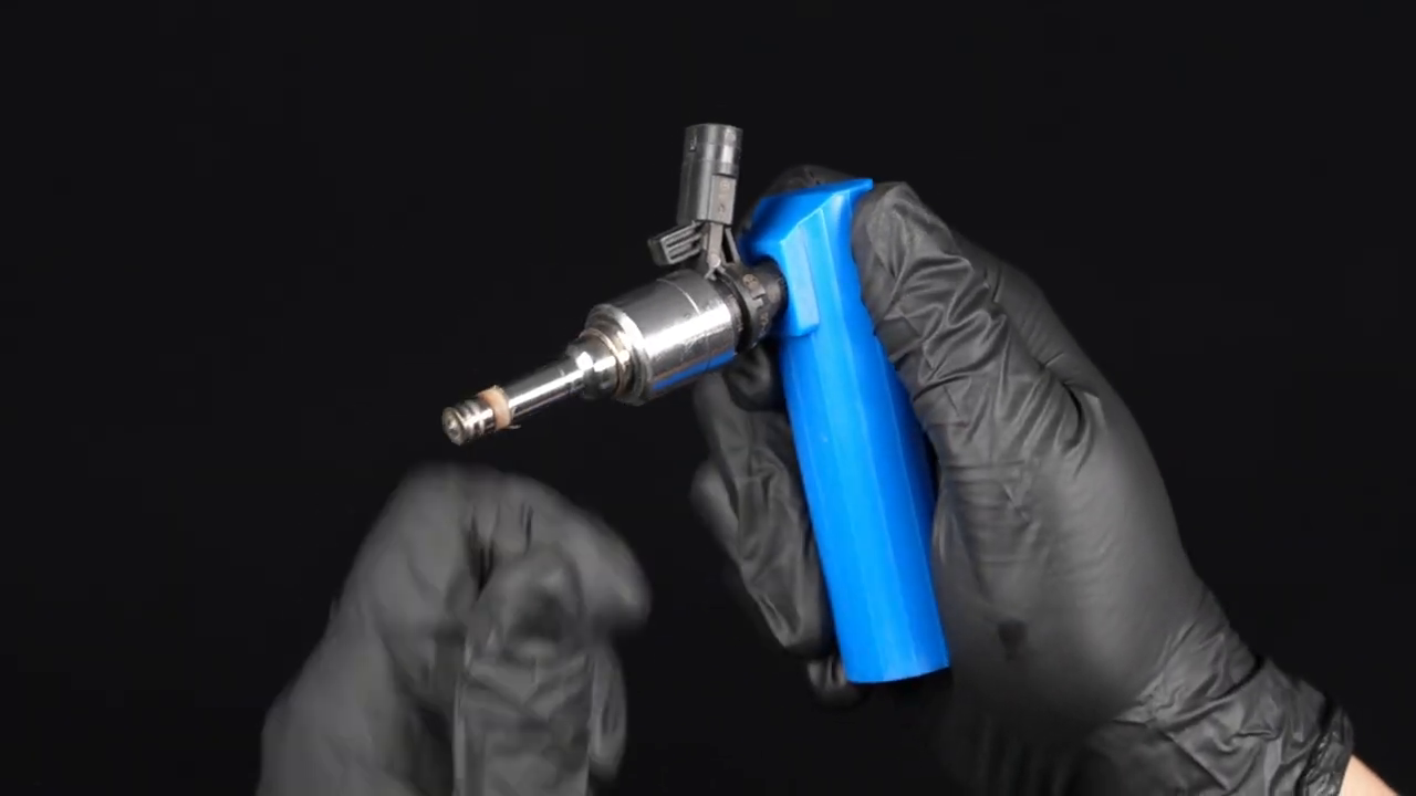 Technician fitting the MRCARTOOL V30 adapter between an injector and an aerosol cleaning-fluid source.