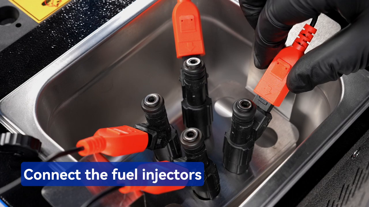 Four injectors in the MRCARTOOL V308 ultrasonic tank with pulse leads attached.