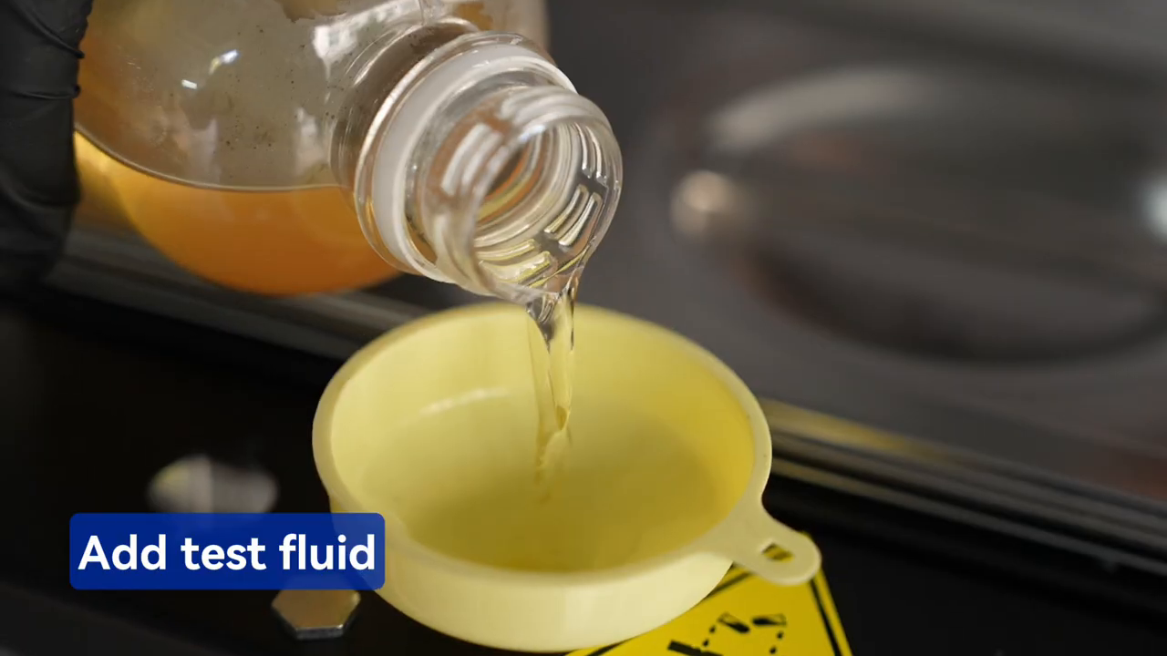 Approved injector test fluid being poured through the MRCARTOOL V310 funnel.