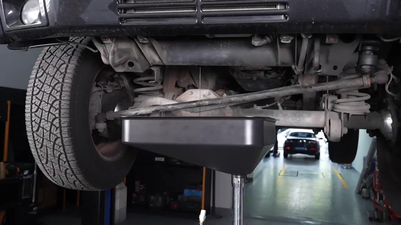 AUTOOL OD720 catch pan centered beneath a mechanically supported vehicle for gravity oil drainage