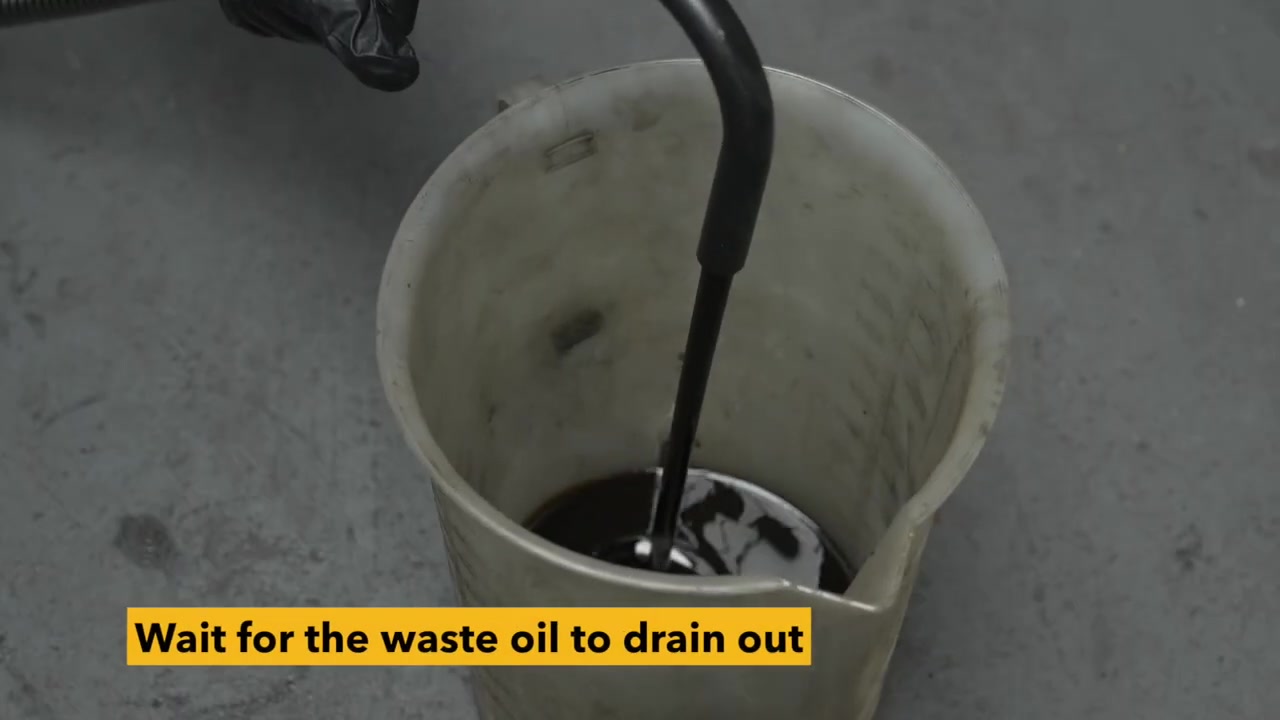 AUTOOL OD720 drain hose secured inside a receiving container during waste-oil tank discharge