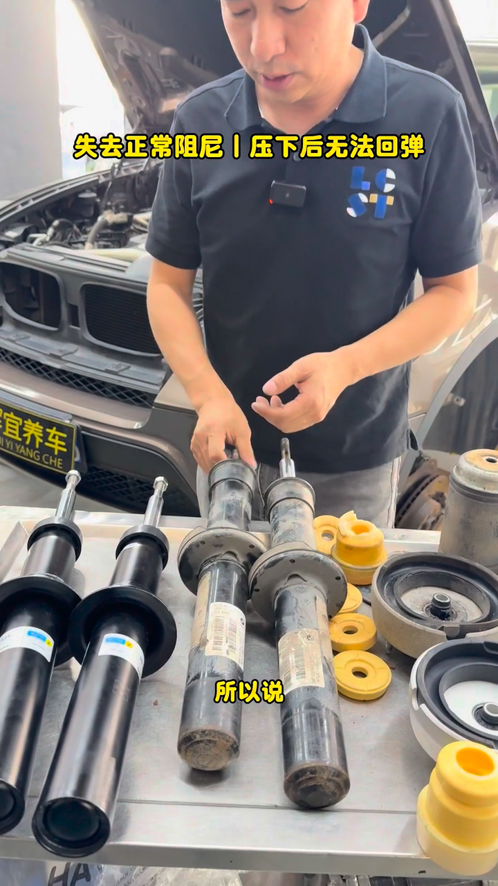 Two removed BMW X5 front dampers beside two replacement dampers