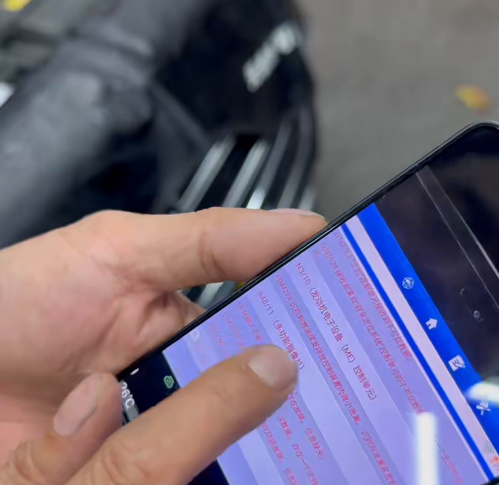 Handheld diagnostic display showing fault code P04427A beside the Mercedes