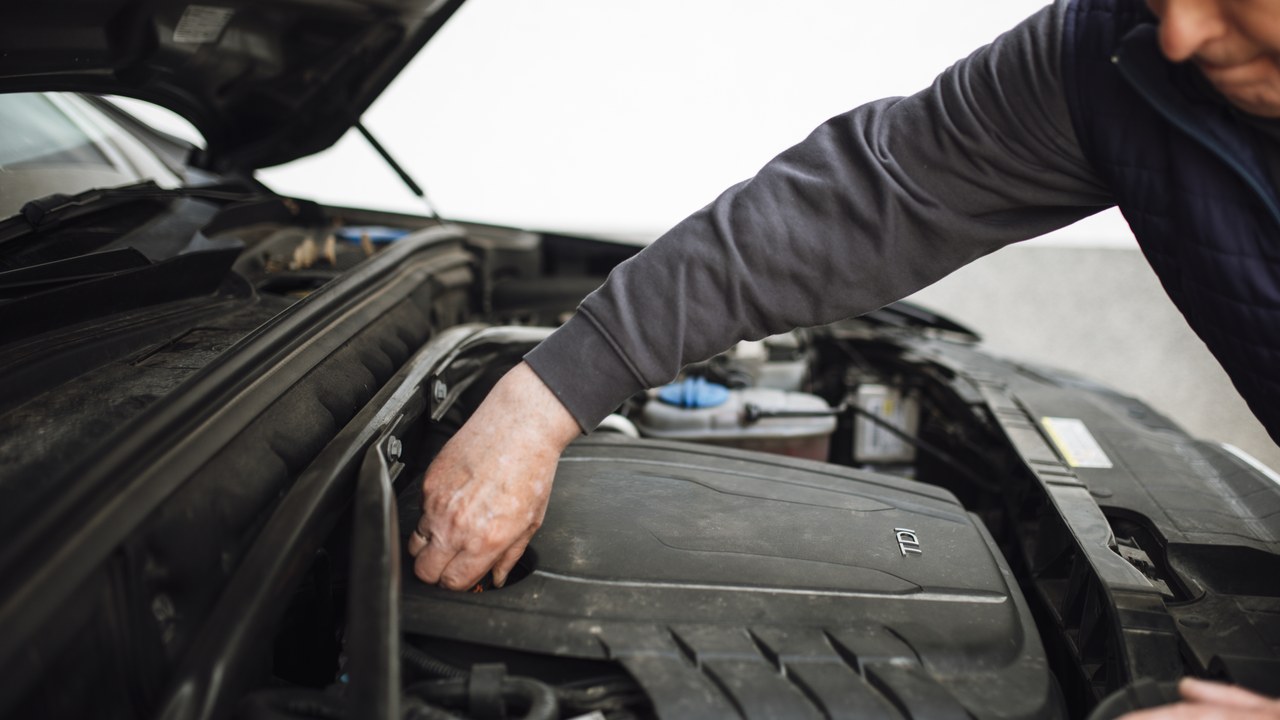 Mechanic inspecting an open engine bay during routine maintenance