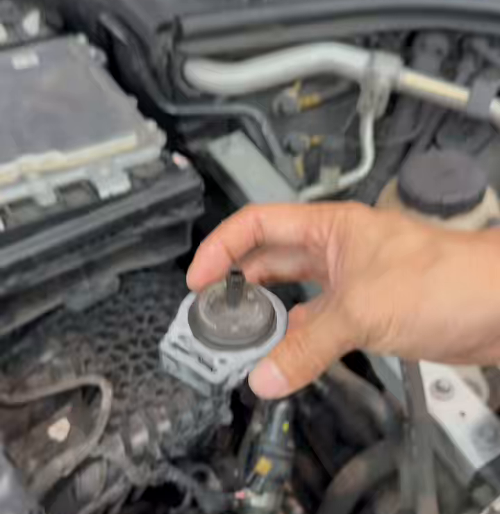 Purge valve Y58/1 held above its location in the Mercedes engine bay