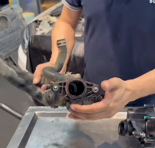 Close view of the removed thermostat housing and joint area.