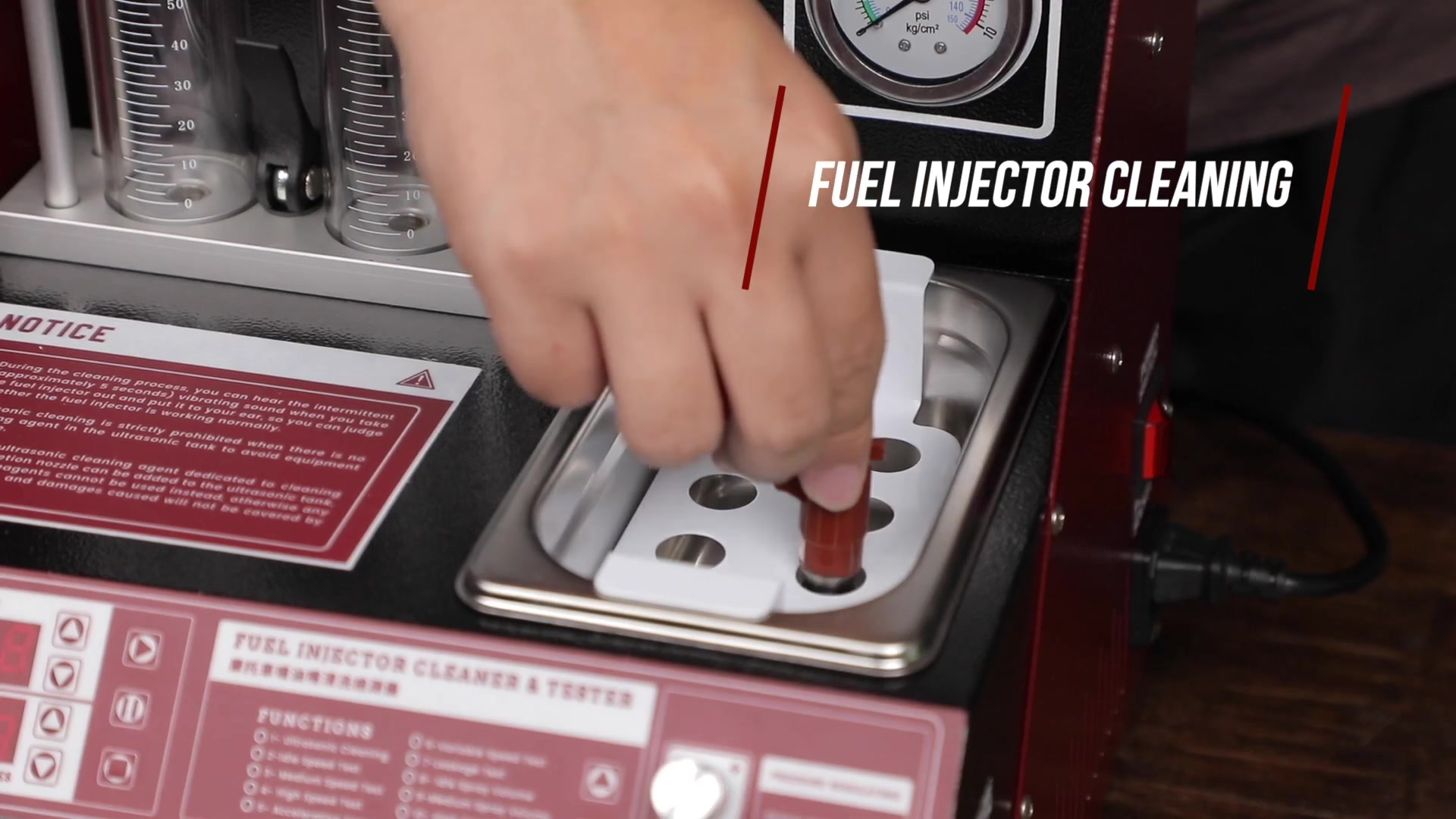 Two removed motorcycle fuel injectors supported above the UNT60 ultrasonic bath