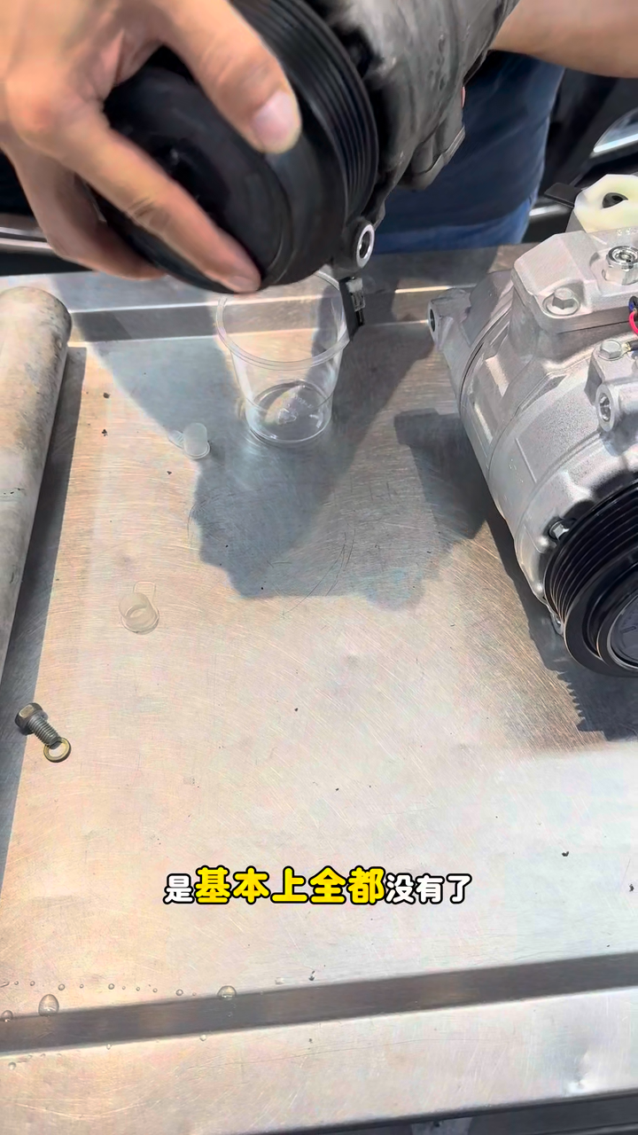 Small amount of refrigeration oil draining from the removed compressor.