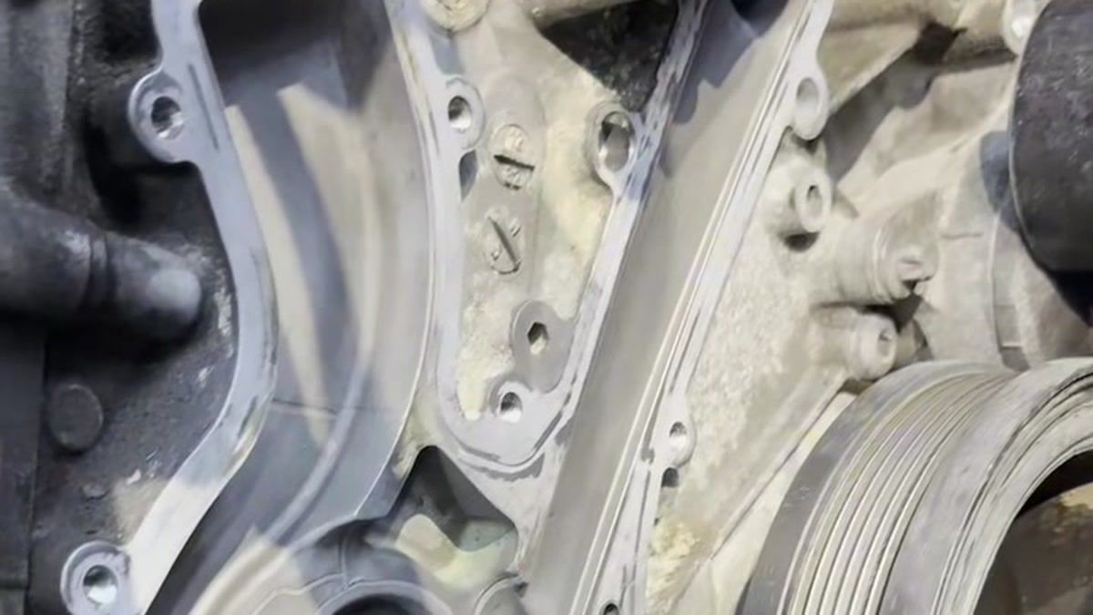Exposed water-pump mounting surface beside the engine pulley.